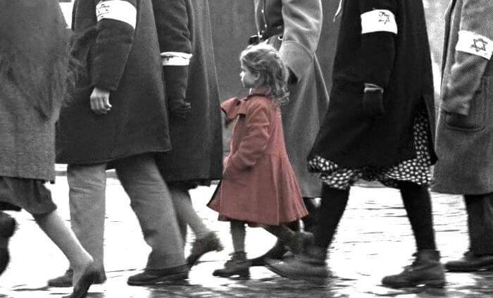 The lonely little girl in Red walking along with the adults during the Plaszow ghetto massacre. 