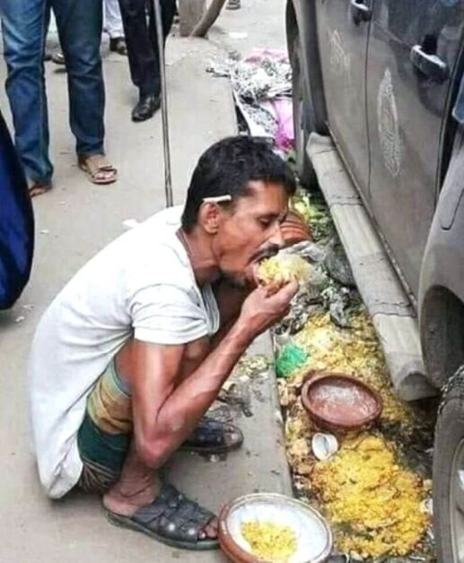 A man eating from the road gutter in Bangladesh